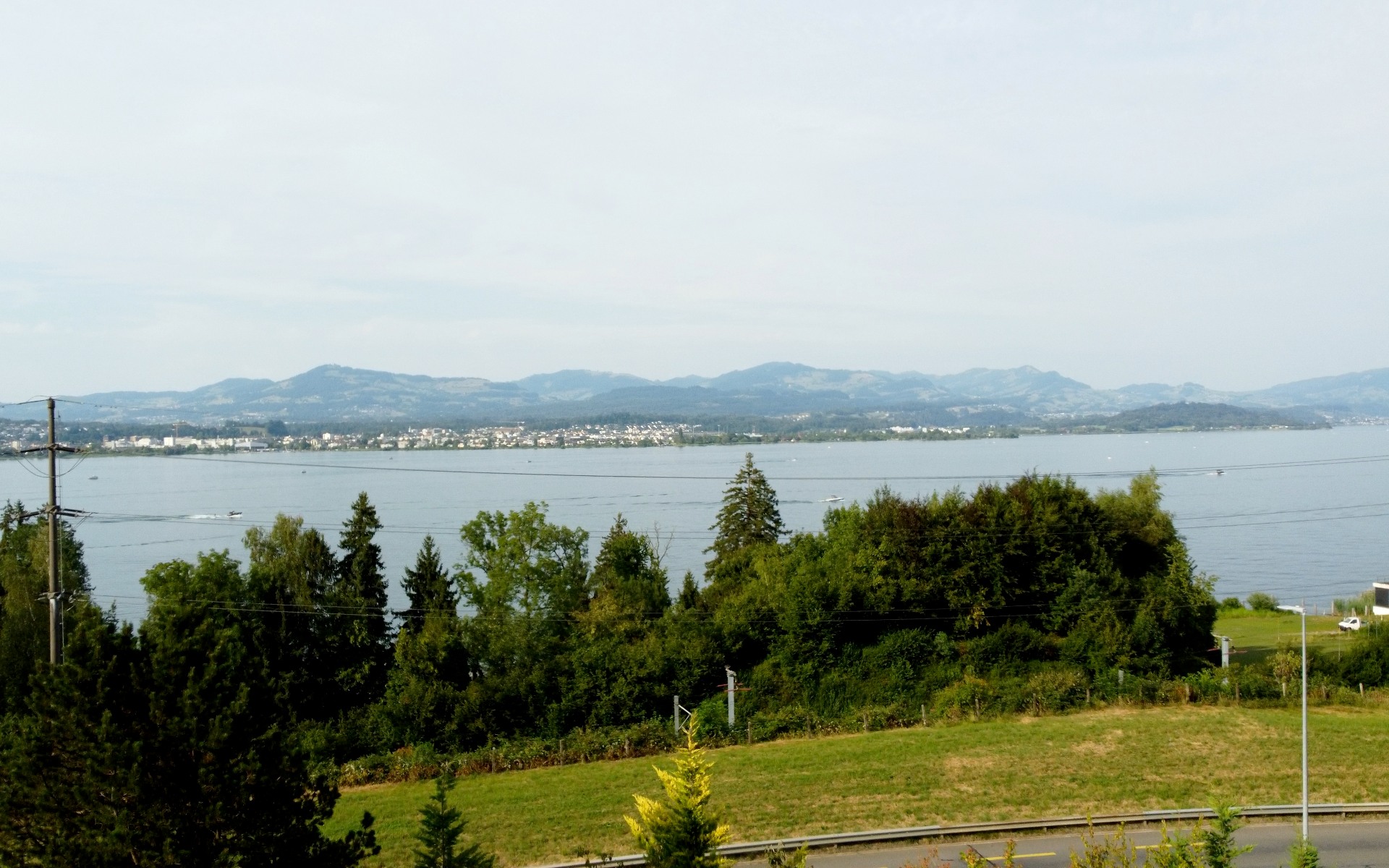 Erhöhte Perspektive über das Grundstück hinweg auf den Zürichsee und das gegenüberliegende Ufer